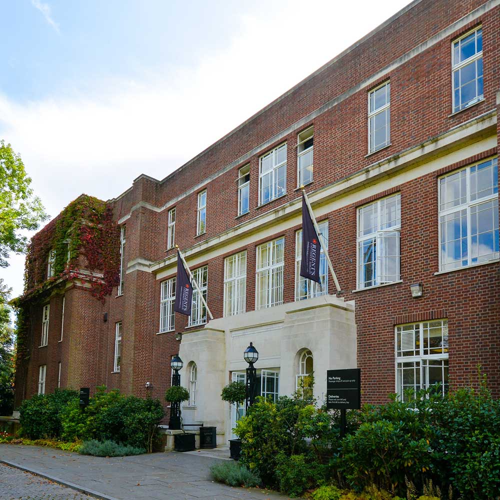 front façade of regents university where axis undertook a renovation project. Shows school flags and large windows behind floral front