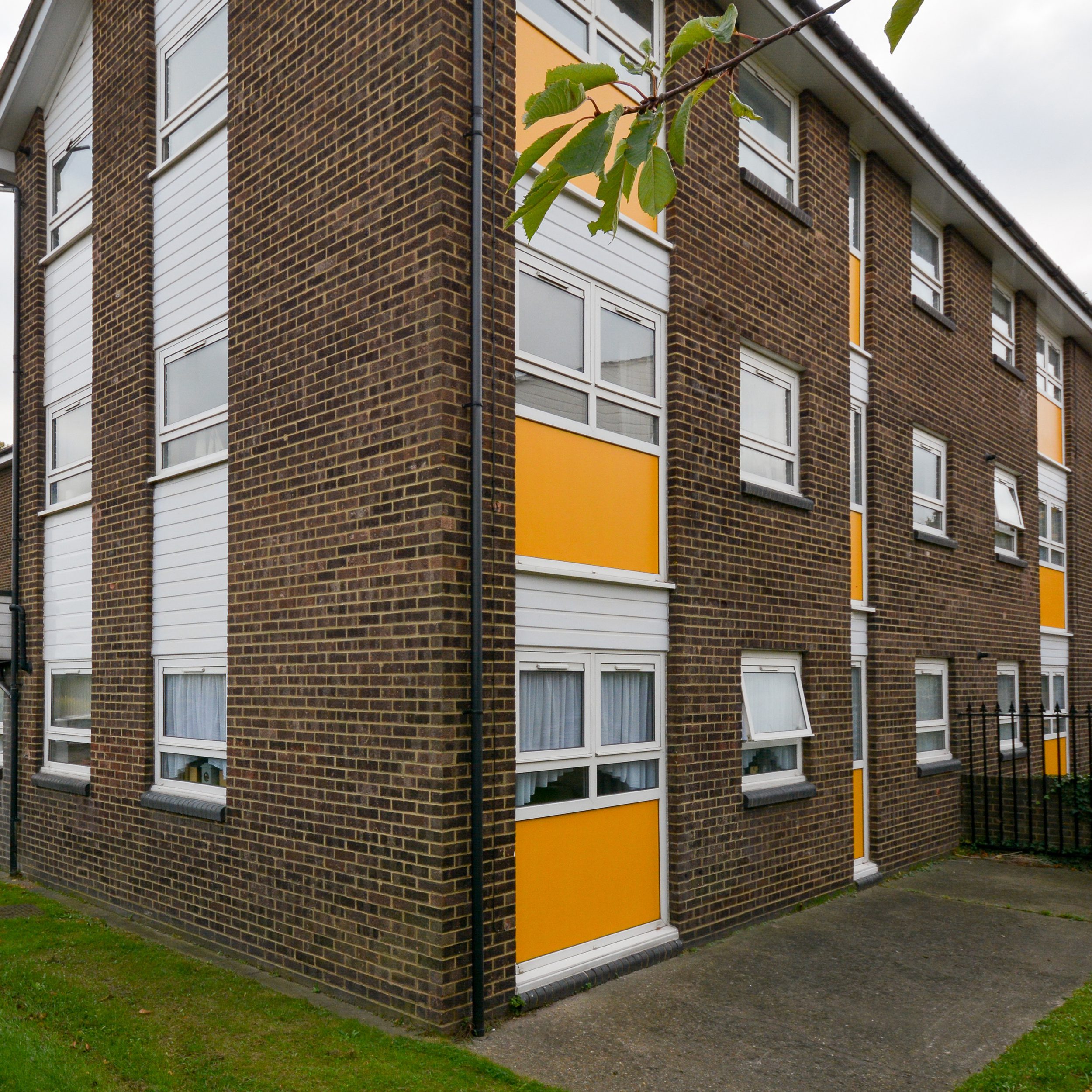 Light orange panels below windows on a housing property shows the finished works after repairs