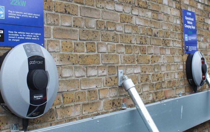 Met-police-electric vehicle charging ports against a brick wall