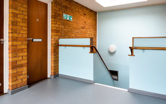 Staircase inside a residential property refurbishment shows a landing area with blue painted walls and new door installation