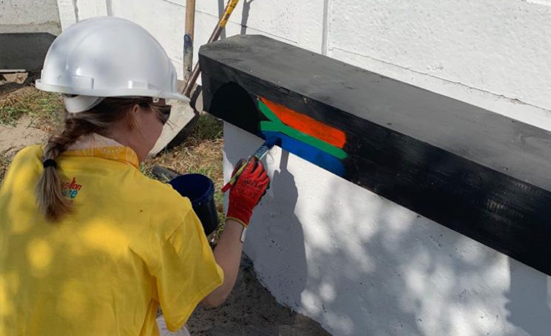 Axis apprentice Fran painting and decorating a school in south africa as part of axis commitment to volunteering