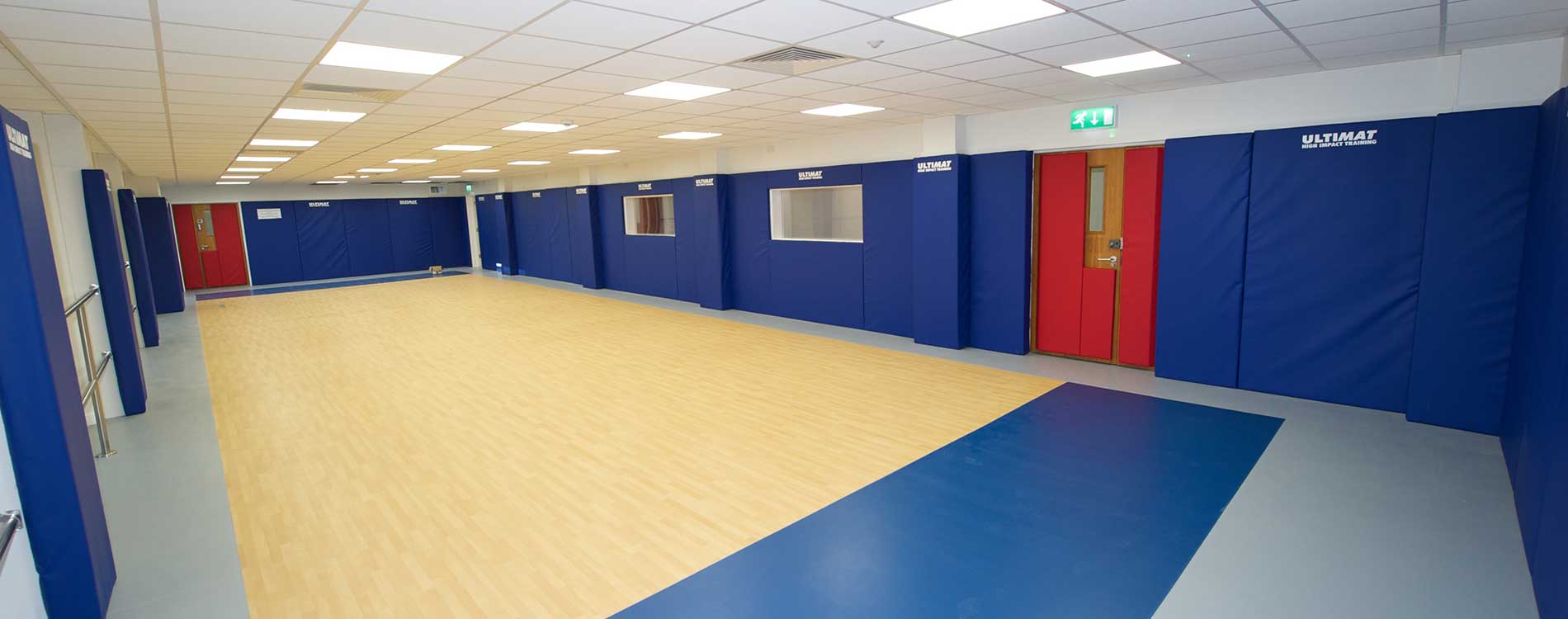 Gymnasium with blue padded walls after a large renovation
