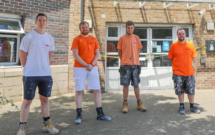 Axis apprentices standing outside a community Action centre