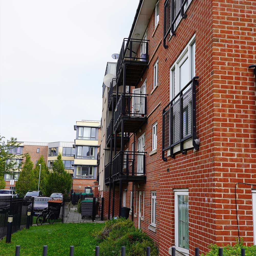 Side view facade of red brick flats with juliette balconies