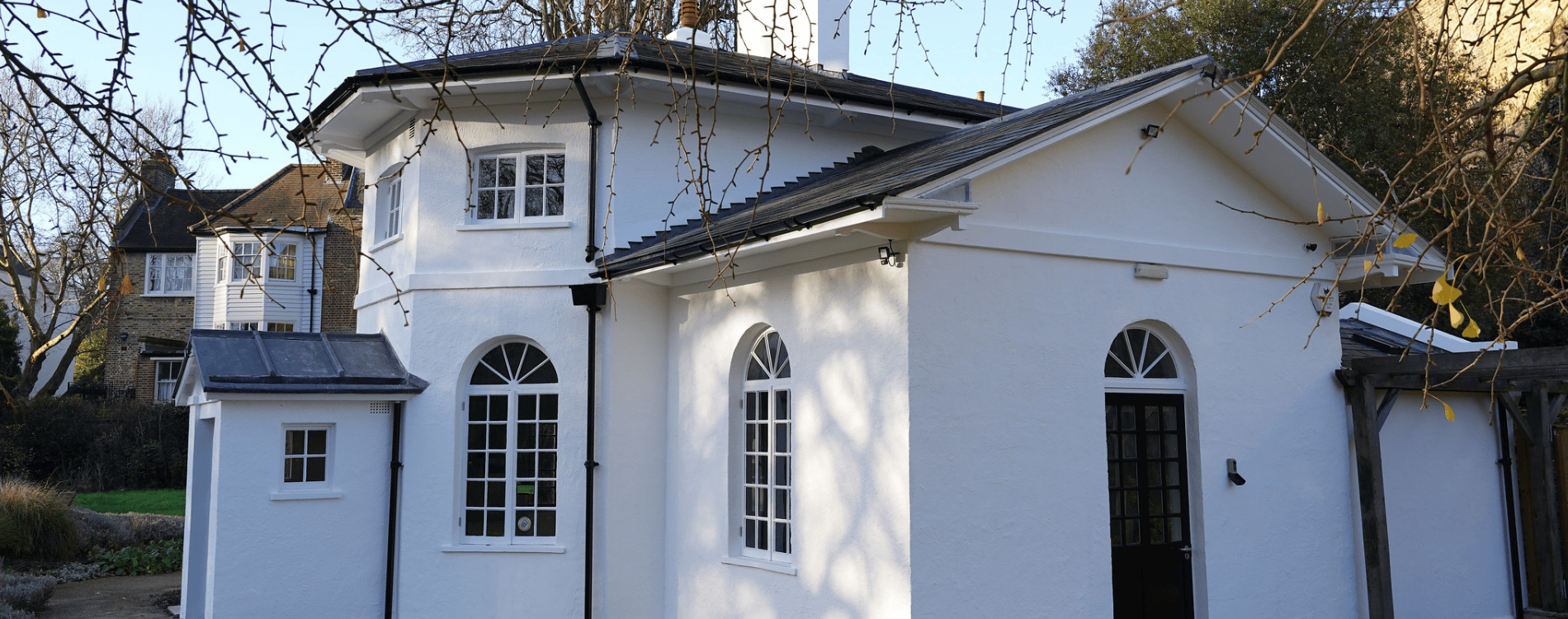 Old white house with black roofs, windows and doors.