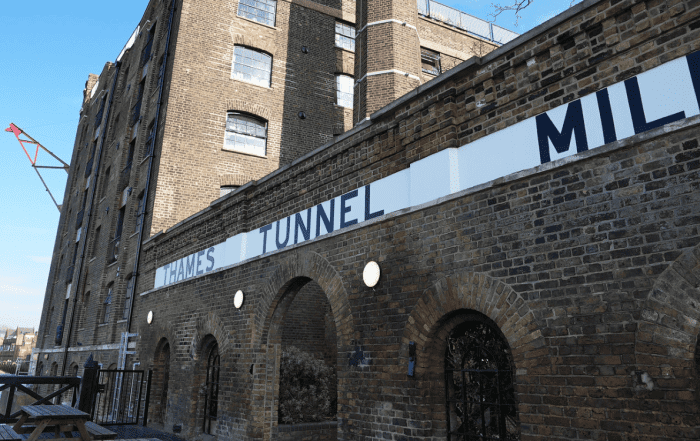 Thames Tunnel Mills sign along side elevation of brick building with arches