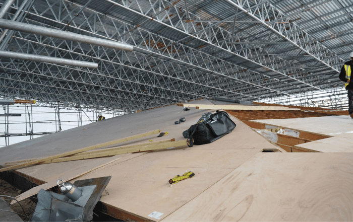Wooden rooftop with metal structure and men at work