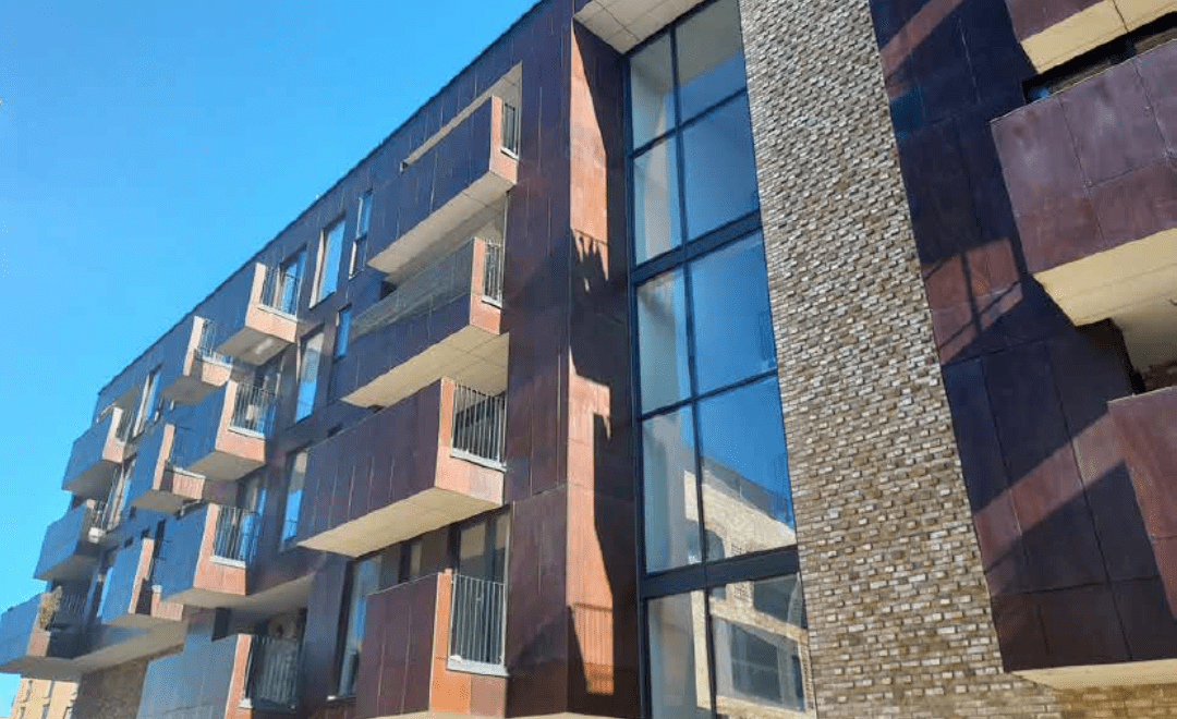 facade of bloack of flats with brown exterior and high windows