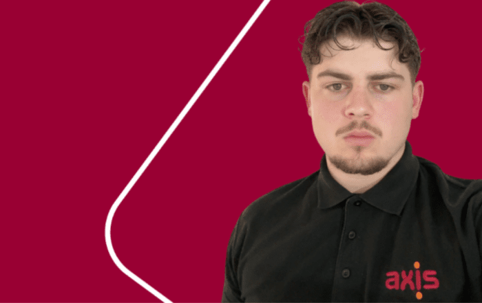 boy standing in front of a red background wearing an Axis t-shirt