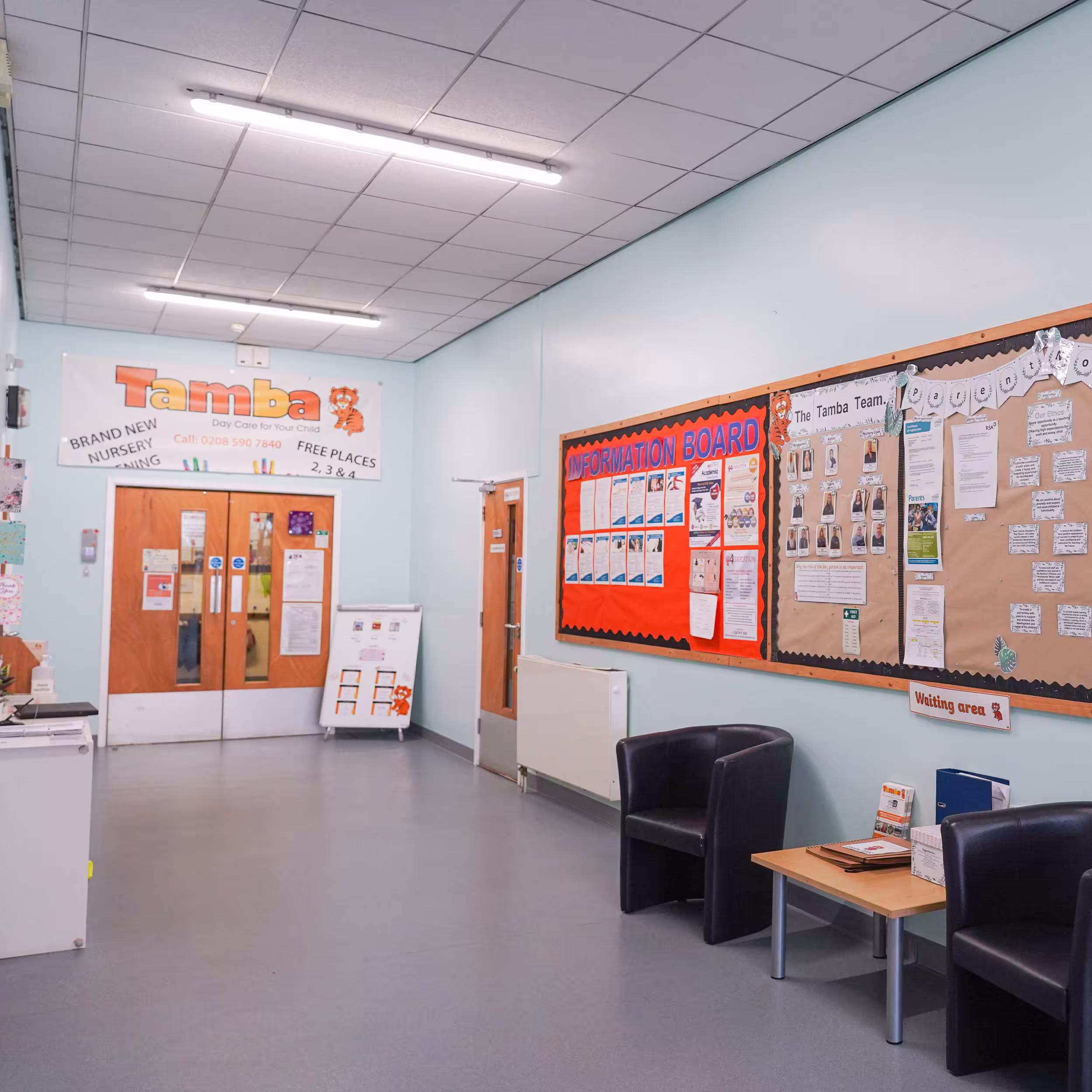 The redecorated waiting and information area of a community centre, with freshly painted walls, large noticeboards, and signage for the Tamba Day Care nursery.