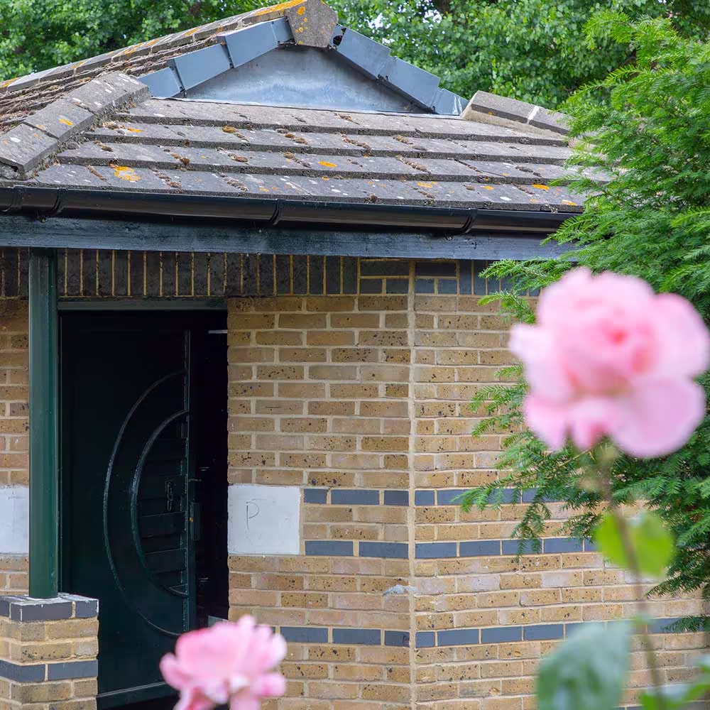 A well-maintained brick outbuilding in the grounds of a residential property, showcasing the comprehensive nature of an external maintenance contract.