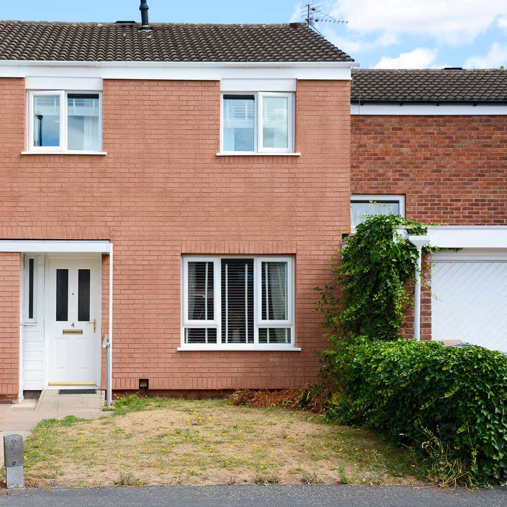 Wide shot of a semi-detached house with lawn and pathway highlighting the completed Axis external wall insulation installation.