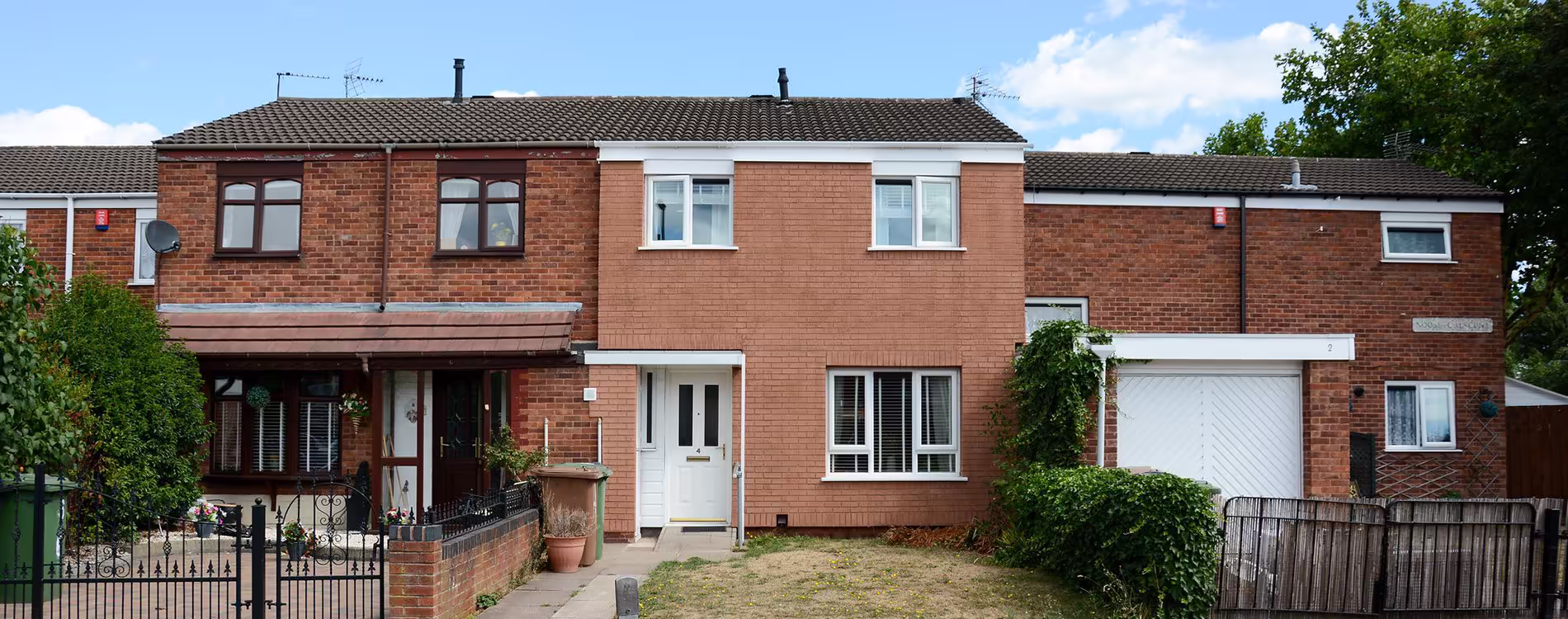 Front elevation of a semi-detached home showing new external wall insulation with crisp white render around the door and windows.