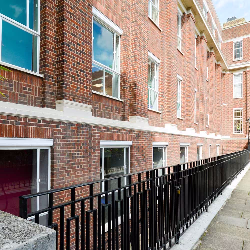 Freshly painted handrail and restored brick pier leading into the renovated Regent's University campus.