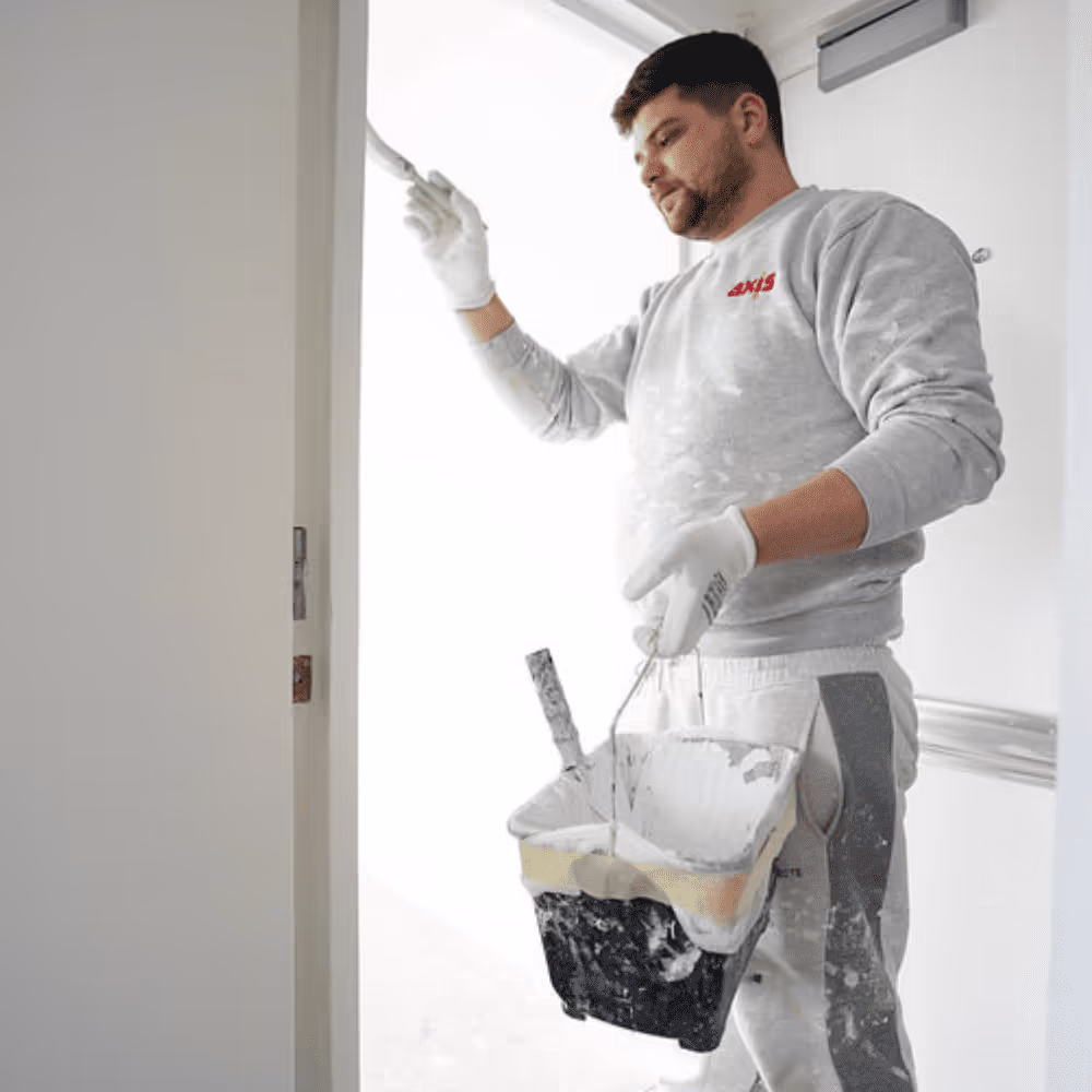 A professional painter from Axis at work, painting the interior of a flat during a major renovation programme.