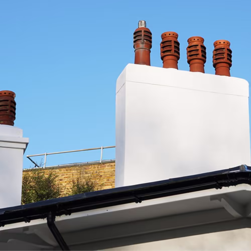 A newly refurbished and painted white chimney stack with restored traditional terracotta chimney pots, a key detail of the Grade II listed building's refurbishment.