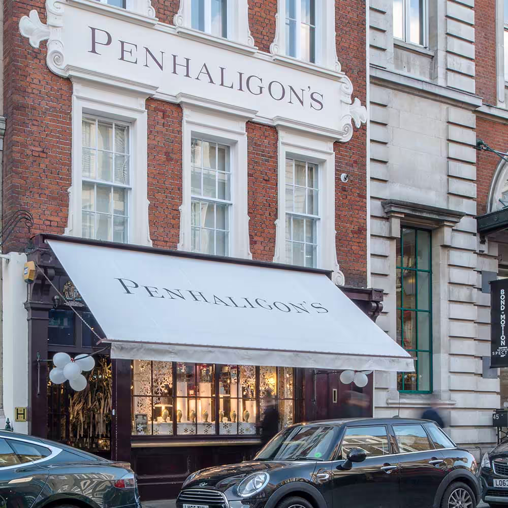 The beautifully repaired shop front of the Penhaligon's heritage building, showing the clean white awning, restored facade, and intricate window display.