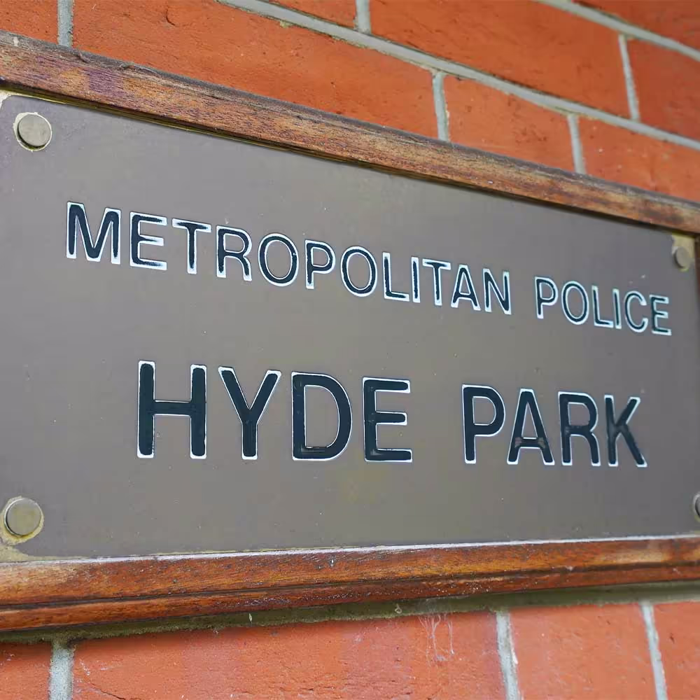 The official 'Metropolitan Police Hyde Park' sign mounted on the exterior red brick wall of the heritage building.