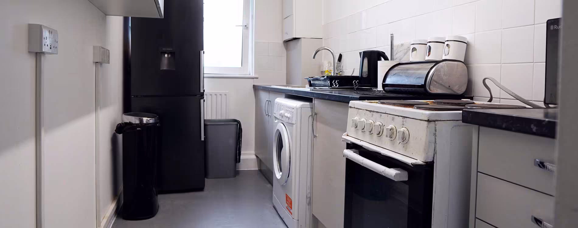 A panoramic view of a dated kitchen in a Westminster City Council property before its full replacement and refurbishment.
