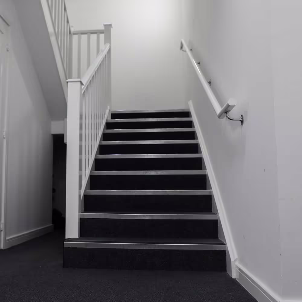 Looking up a clean, newly decorated communal staircase in a residential block after minor repairs and redecoration works.