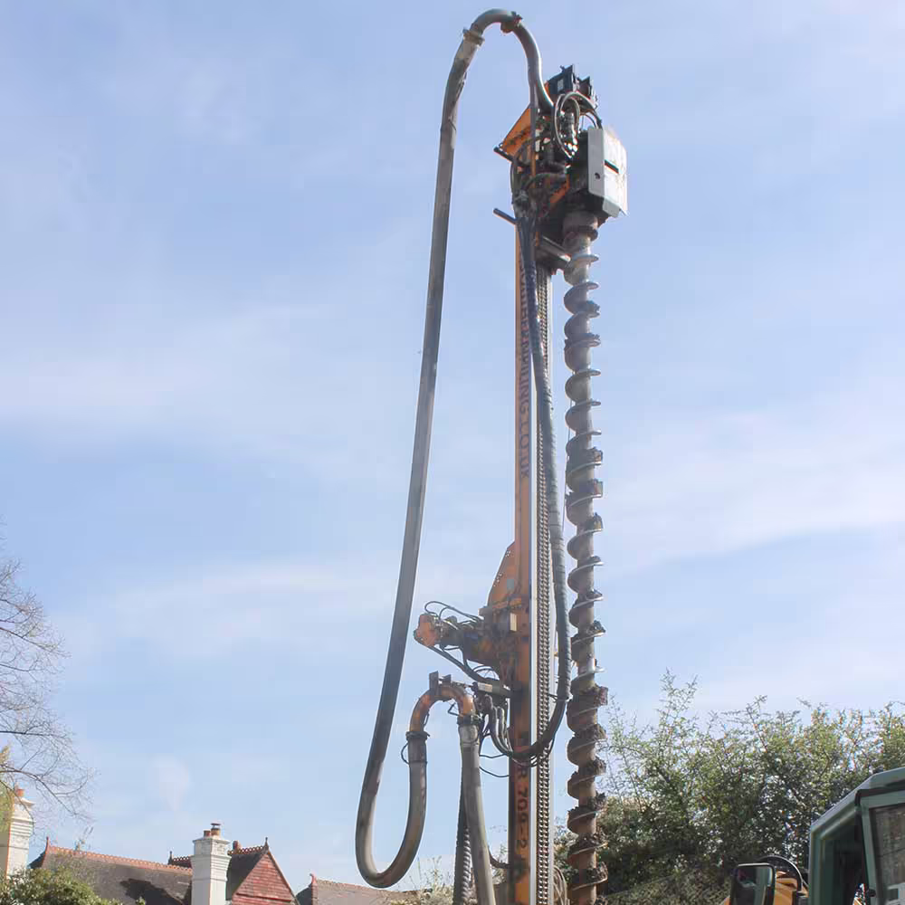 Wide shot of cranes and machinery constructing a new-build housing complex.