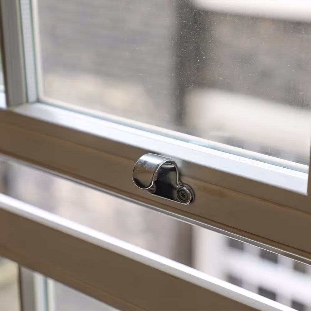 A close-up of a new chrome sash window lift, demonstrating the detailed hardware replacement undertaken during a residential window repair project.