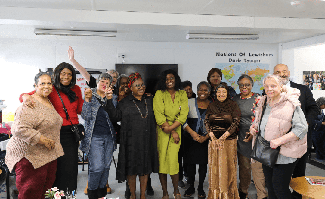 Group photo of women in colourful clothing in a room.