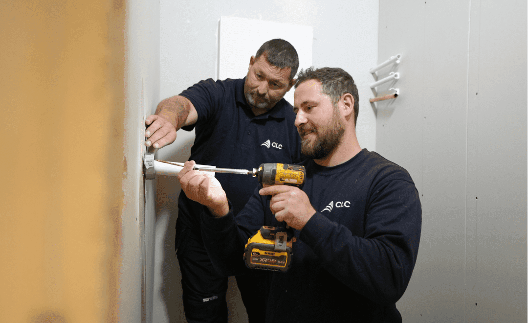 Two operatives installing a fire door