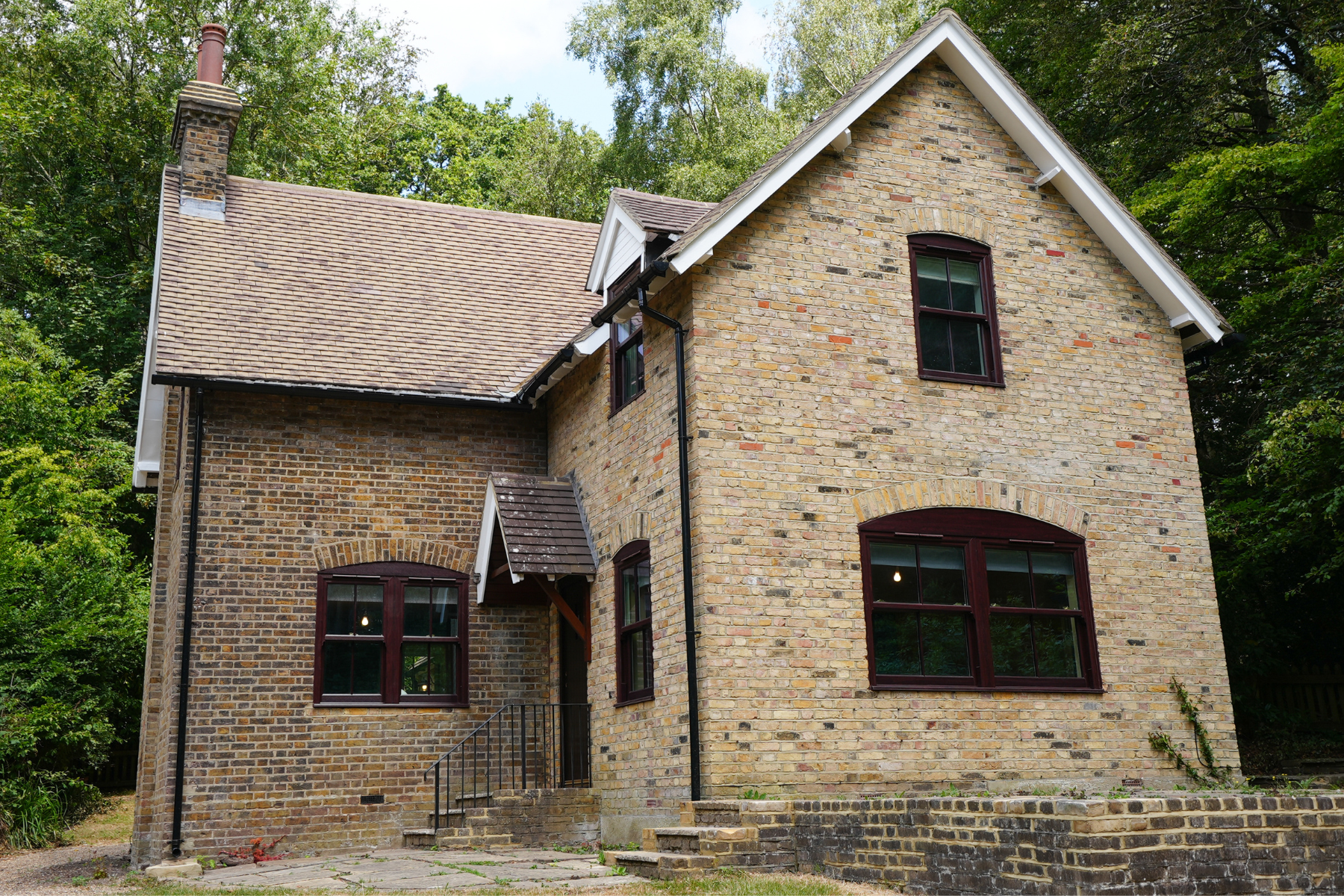 Exterior shot of brick building with brown windows in forest setting