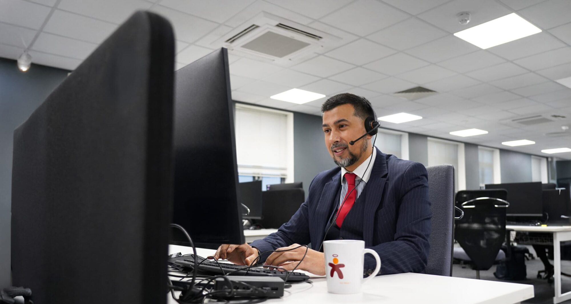 Axis office employee working at a text with a headset on.