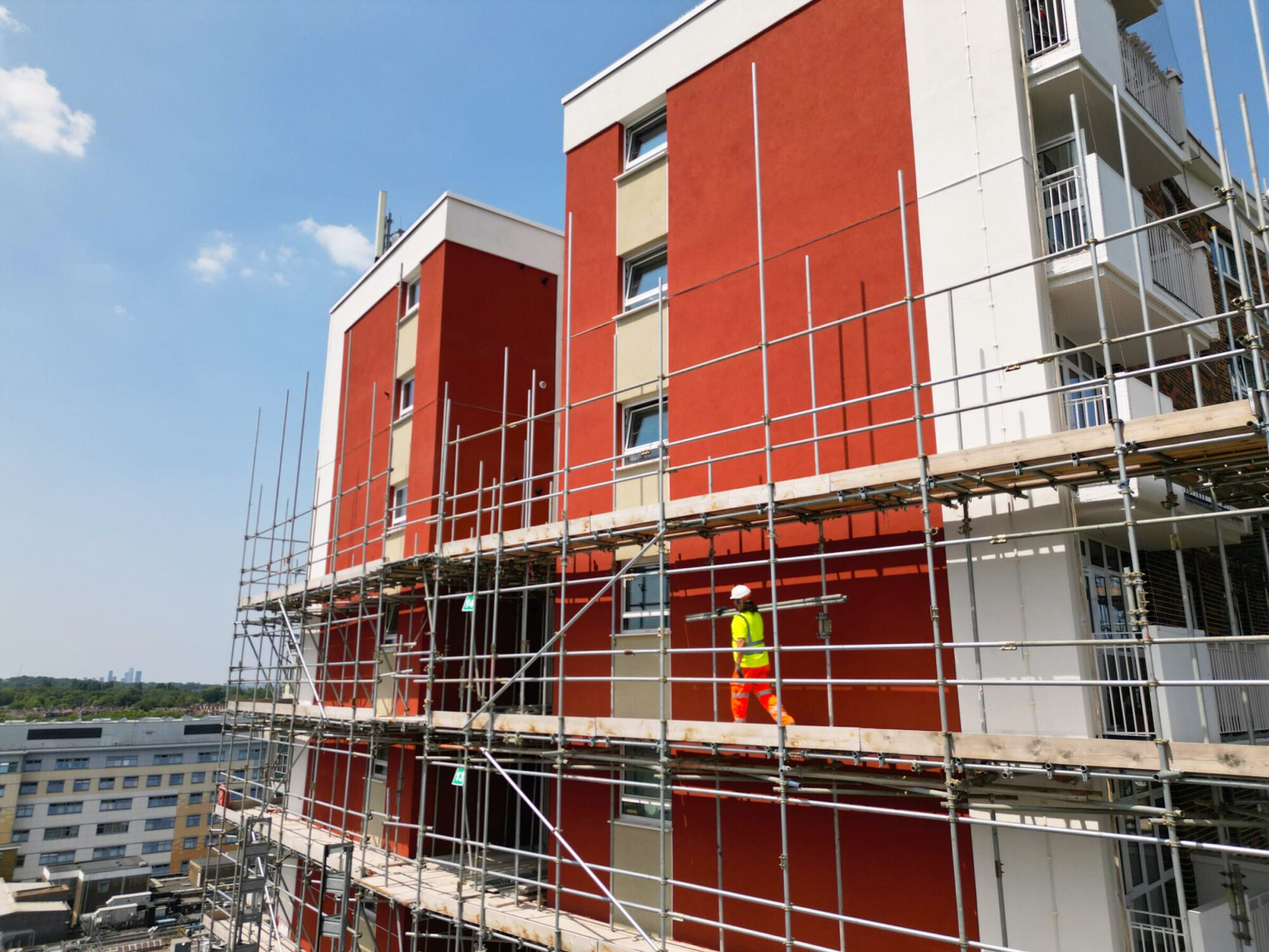 operatives working on a high rise building from scaffolding.