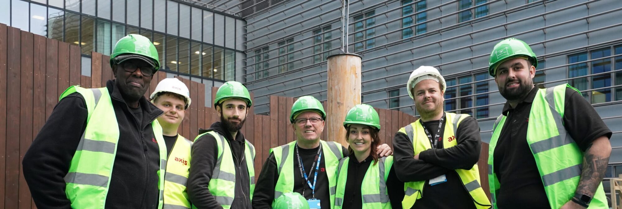 men and women operatives in group photo in high vis smiling at camera