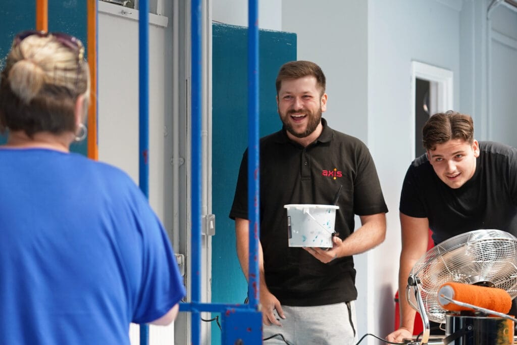 Operatives at social impact project painting and smiling